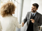 Couple of multiethnic business people handshaking in the office