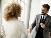 Couple of multiethnic business people handshaking in the office