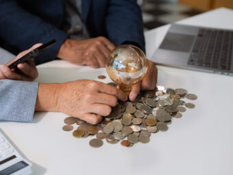 businessman hand holding lightbulb with using laptop computer an